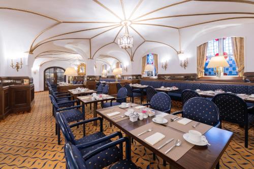 a restaurant with wooden tables and blue chairs at Parkhotel 1901 Mannheim in Mannheim