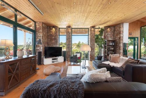 a living room with a couch and a tv at 4 BD Luxurious villa with swimming pool in Sálakos