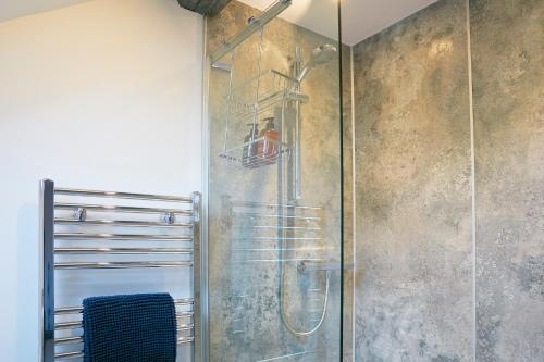 y baño con ducha y puerta de cristal. en The Old Tackroom, luxury Barn. en Sleights