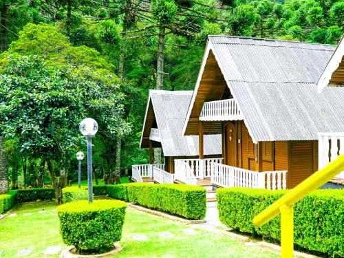 a small wooden house with a metal roof at VELINN Áustria Hotel Monte Verde in Monte Verde