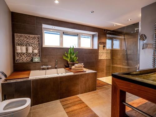 a bathroom with a tub and a toilet and a sink at NOVA Houseboat DELUXE Free Bikes in Amsterdam