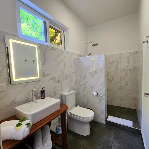 La salle de bains est pourvue d'un lavabo, de toilettes et d'une fenêtre. dans l'établissement Olzadia Boutique Hotel, à Michamvi