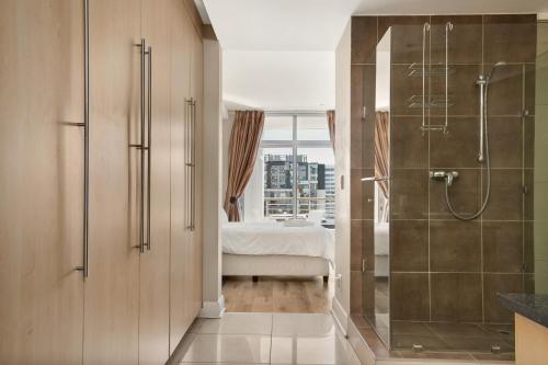 a bathroom with a shower and a bed in a room at Hydro Park Residences in Sandton WITH GENERATOR in Johannesburg