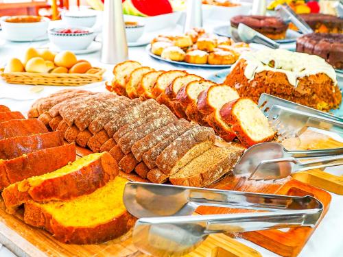 une table remplie de différents types de pain et d’œufs, dans l'établissement VELINN Áustria Hotel Monte Verde, à Monte Verde
