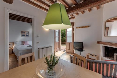 a kitchen and living room with a table and a green lamp at Country House Art and Garden in Monte Antico