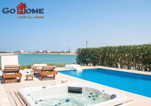 a swimming pool with a jacuzzi tub in front of a swimming pool at Comfort Villa 4 B.Rooms at Fanadir at El-Gouna in Hurghada