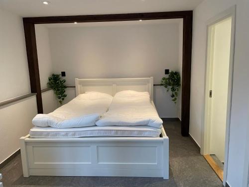 Una cama con sábanas blancas y almohadas. en Solbergshyllan en Åre