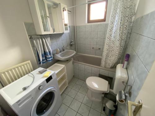 a bathroom with a washing machine and a sink at Ili Vendégház in Zalakaros