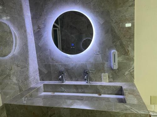 y baño con lavabo y espejo redondo. en HOTEL OTOMI en Otumba de Gómez Farías