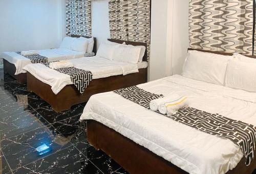 pokój z 3 łóżkami i białą pościelą w obiekcie Stay Inn Station 2 Boracay by RedDoorz w mieście Boracay