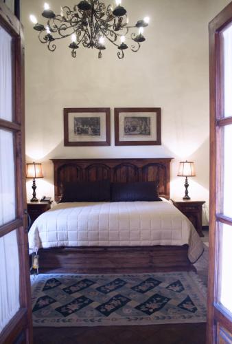 a bedroom with a large bed with a chandelier at Casa Eugenia Hotel in Morelia