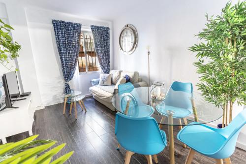 een woonkamer met blauwe stoelen en een bank bij Sailor Apartment nel Cabanyal in Valencia