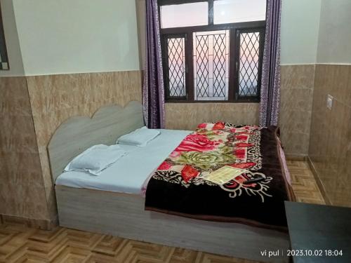 a bed in a room with a window at Hotel heavenly heights in Dhanaulti