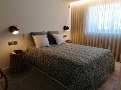 ein Schlafzimmer mit einem Bett mit Kissen und einem Fenster in der Unterkunft Casa de Férias do Parque da Peneda 2 in Vila Verde