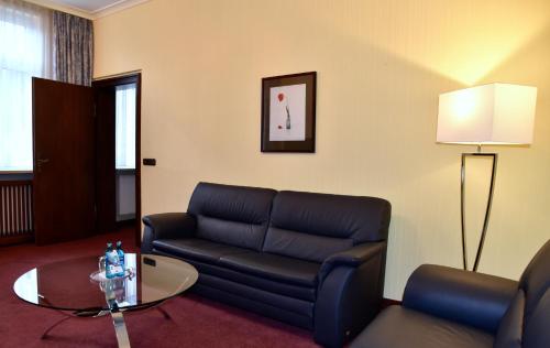 a living room with a couch and a table at Schwarzer Bär Jena in Jena