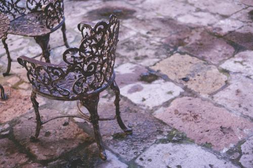a wrought iron bench sitting on a stone ground at Casa Eugenia Hotel in Morelia