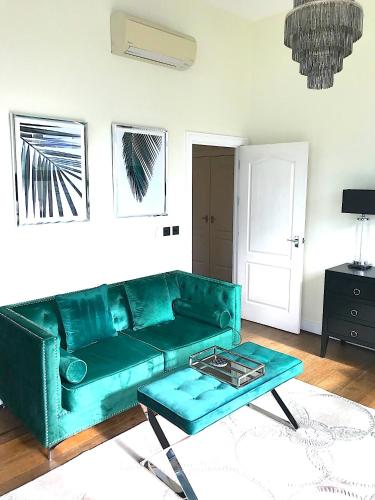 a green couch in a living room with a coffee table at Cloud Nine Luxe Apartment in London