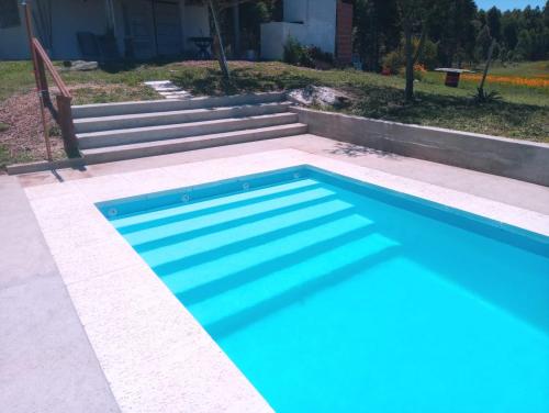 ein blauer Pool mit einer Treppe im Hintergrund in der Unterkunft Los Agapantos in Concordia