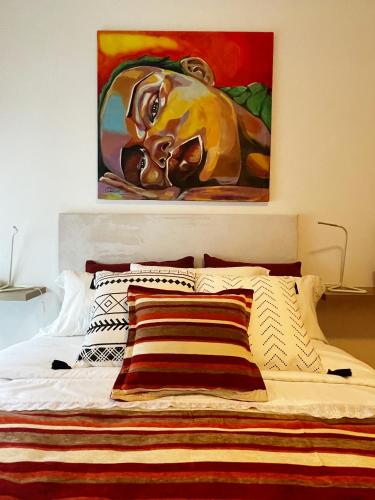 a bed with a painting on the wall above it at Apartamento Centro de Pontevedra in Pontevedra