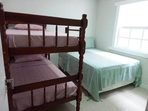 a bedroom with two bunk beds and a window at Quarto Privativo in Cabo Frio