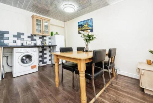 a kitchen with a wooden table and black chairs at 1 bedroom flat in Luton free parking in Luton