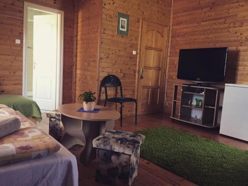 a living room with a tv and a table with a table sidx sidx at Hubertus Vendégház in Parád