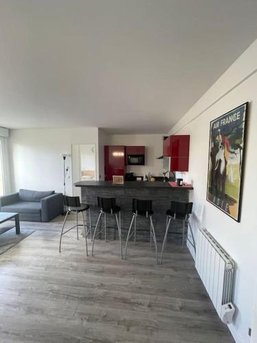 Il comprend un salon avec un canapé et une cuisine avec des tabourets. dans l'établissement Cosy Apartment with Private Parking, à Saulx-les-Chartreux