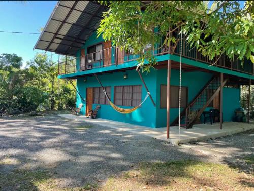 a blue building with a hammock in front of it at Casa Patricia in Uvita