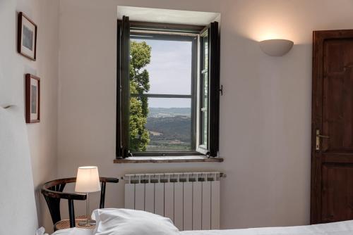 a bedroom with a bed and a window at Country House Art and Garden in Monte Antico