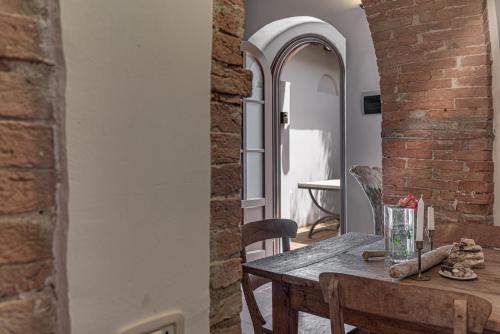a dining room with a table and a brick wall at Country House Art and Garden in Monte Antico