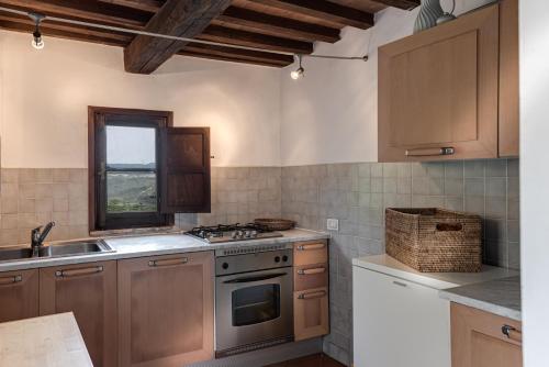 a kitchen with wooden cabinets and a stove top oven at Country House Art and Garden in Monte Antico