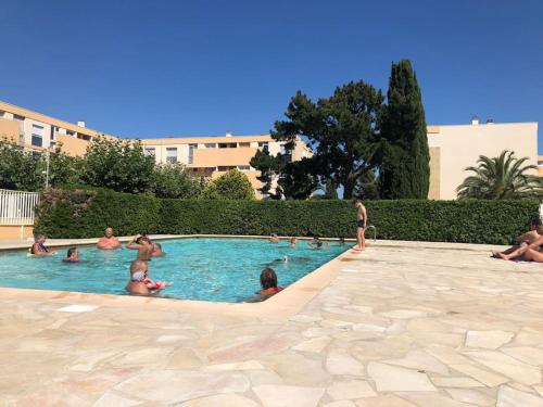 un groupe de personnes dans une piscine dans l'établissement Nice family apartment close to the beach, au Lavandou