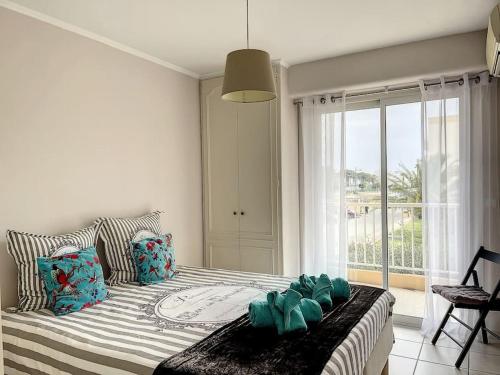 a bedroom with a bed and a large window at Nice family apartment close to the beach in Le Lavandou