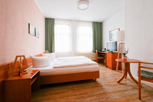 a hotel room with a bed and a desk at Landhaus Falkenstein in Tambach-Dietharz