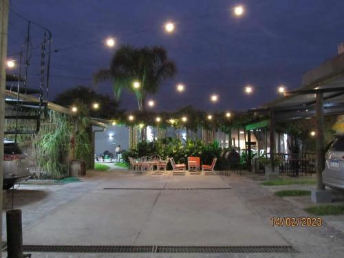 a parking lot with tables and chairs at night at Alemar Termas Hotel in Termas de Río Hondo