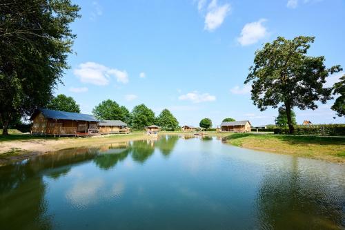 a river with houses in the middle of it at Glamping Betuwe in Kesteren