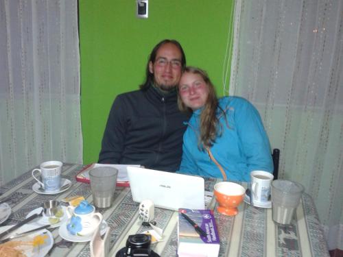 a man and woman sitting at a table with a laptop at Arum Qurpawasi Hospedaje in Cabanaconde