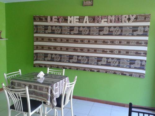 a dining room with a table and chairs and a wall at Arum Qurpawasi Hospedaje in Cabanaconde