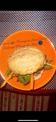 a sandwich on an orange plate on a table at Moonglade Allure Houses in Polyana