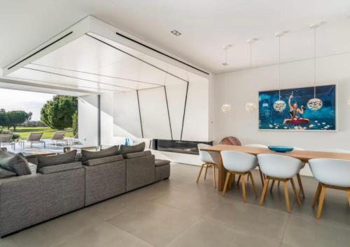 a living room with a couch and a table and chairs at Villa Algarve Paradise in Vilamoura