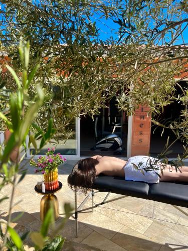 a woman laying on a bench under a tree at La Listrella Residence & Spa in Monticello