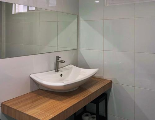 ein Badezimmer mit einem weißen Waschbecken und einem Spiegel in der Unterkunft Monon Antipolo Japanese Onsen Feels in Antipolo
