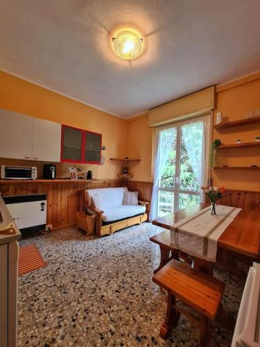 ein Wohnzimmer mit einem Tisch und einer Küche in der Unterkunft Il Posticino di Bellagio in Civenna