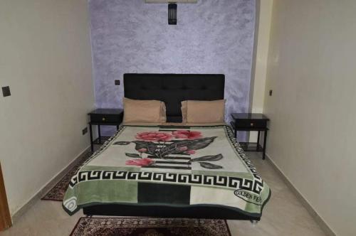 a bedroom with a bed with a bedspread with flowers on it at Appartement a Marrakech in Marrakech