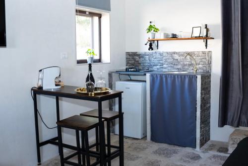 uma pequena cozinha com uma mesa e um lavatório em La Dimora delle Coste em Comiso
