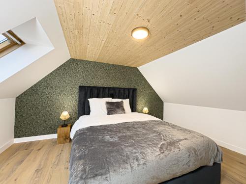 a bedroom with a bed and a green wall at Mr.Bernard Vakantie Appartementen in De Panne