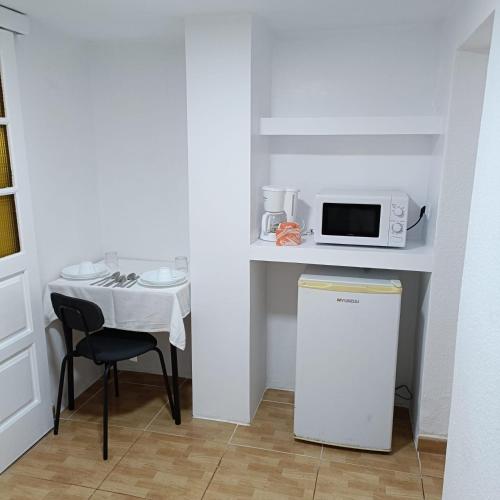a small kitchen with a table and a microwave at Hotel Casa del Sol in Puerto de la Cruz