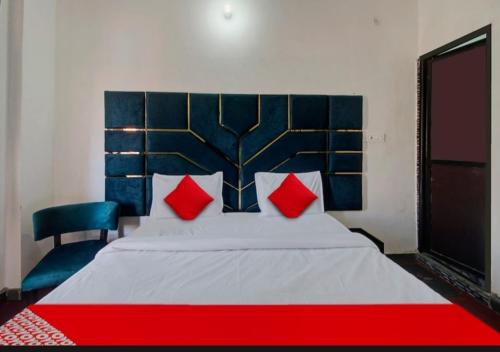 a bedroom with a large bed with red pillows at HOTEL SHREE KANHA in Jaipur