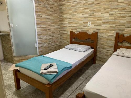 1 dormitorio con 2 camas, toallas y espejo en Pousada terraco Rio Centro, en Río de Janeiro