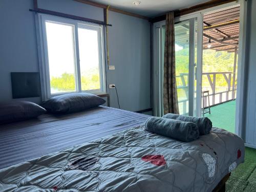 a bedroom with a bed with two pillows on it at Baan Plai Laem Homestay at Koh Paluay in Koh Phaluai